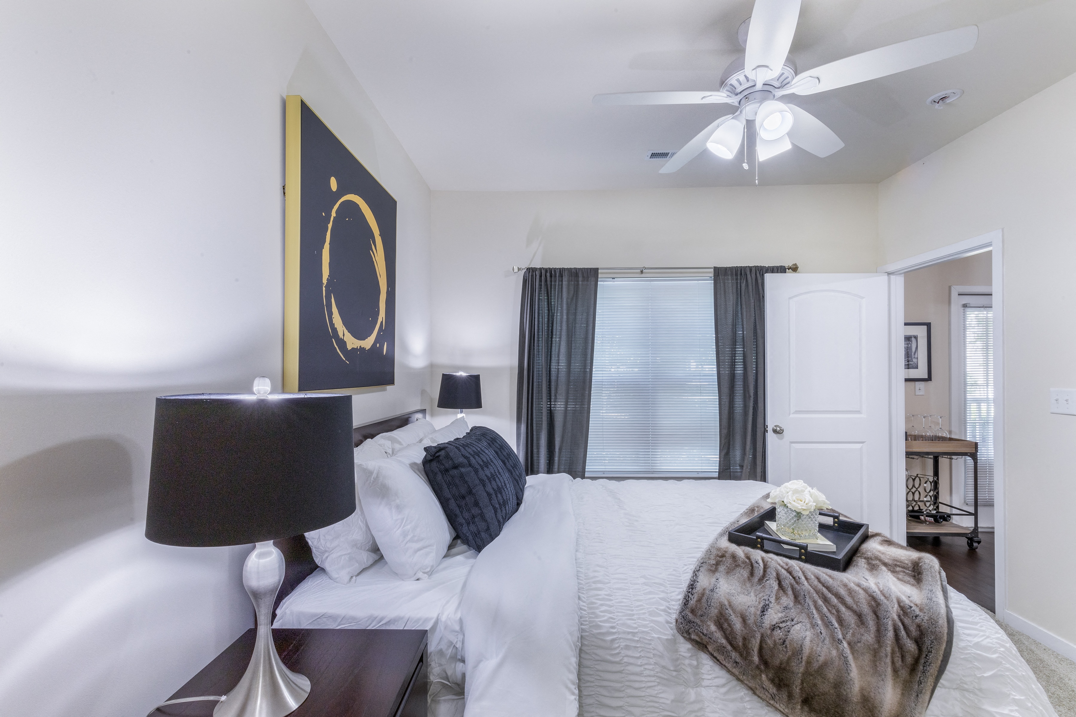 a bedroom with a large bed and a ceiling fan at Aventura at Forest Park, St. Louis, MO